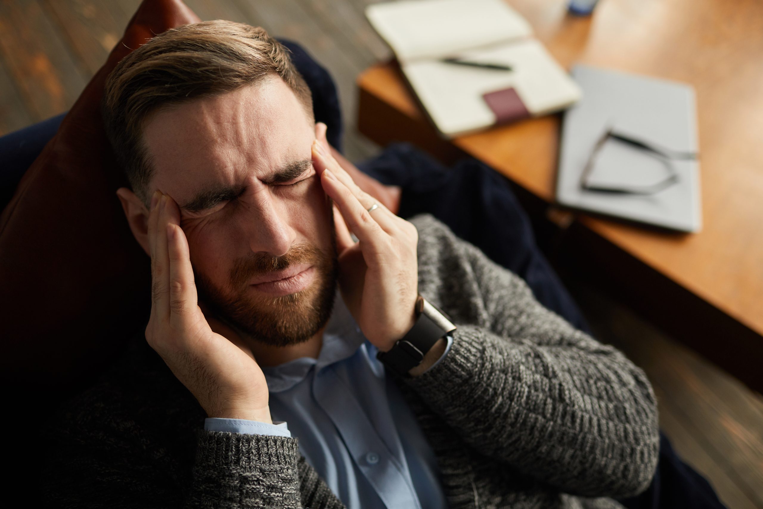 Young businessman has a headache he lying on the sofa and resting after work
